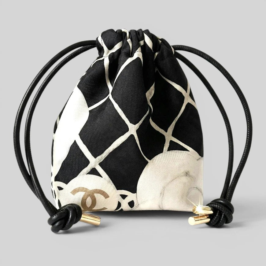 Prettysac black and white patterned drawstring pouch with gold accents and black cords.