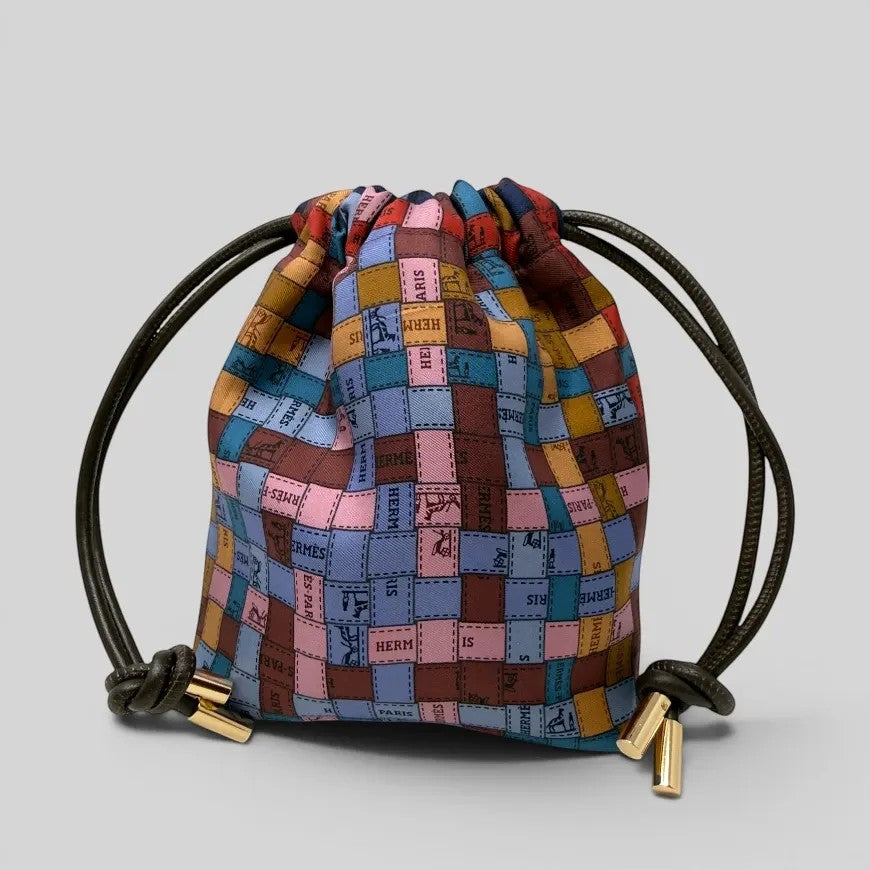 Prettysac artisanal patchwork pouch with dark brown leather drawstring and gold-tone hardware, featuring a colourful scarf print.