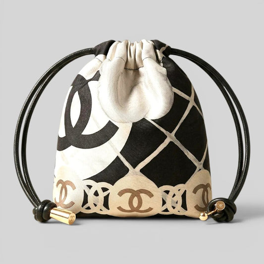 Prettysac black and white patterned drawstring pouch with gold accents and black leather cords.