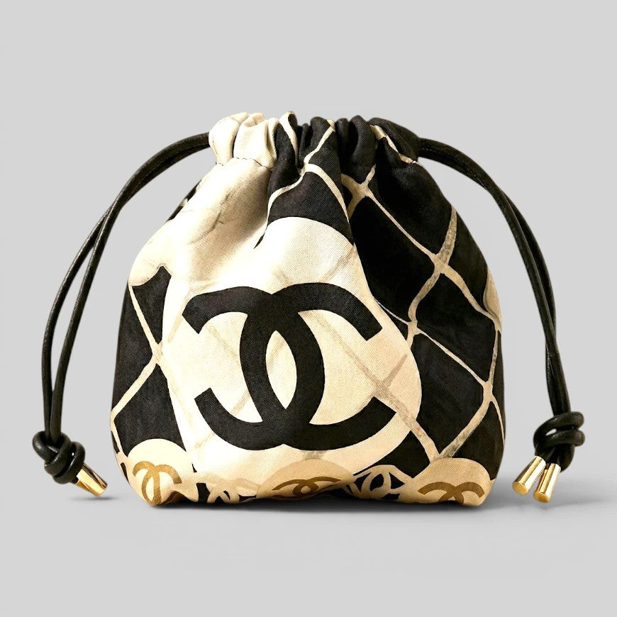 Prettysac black and white patterned drawstring pouch with gold accents and black leather cords.