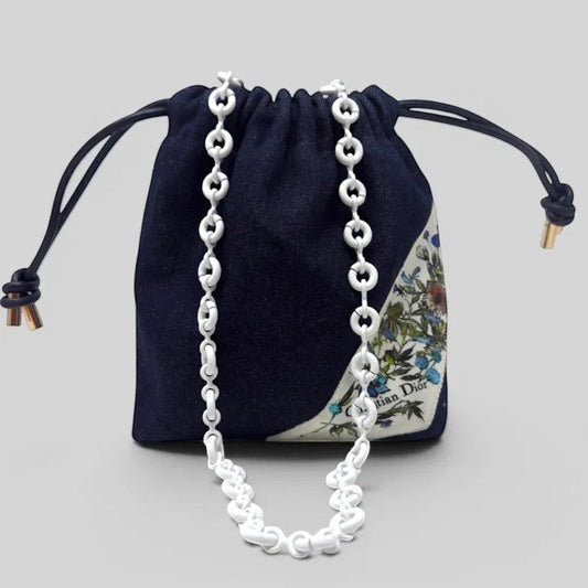 Prettysac Christian Dior dark wash denim drawstring pouch with floral print and white chain strap.