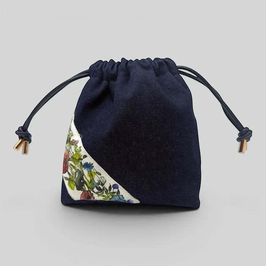 Prettysac dark wash denim drawstring pouch with floral print accent and leather ties.