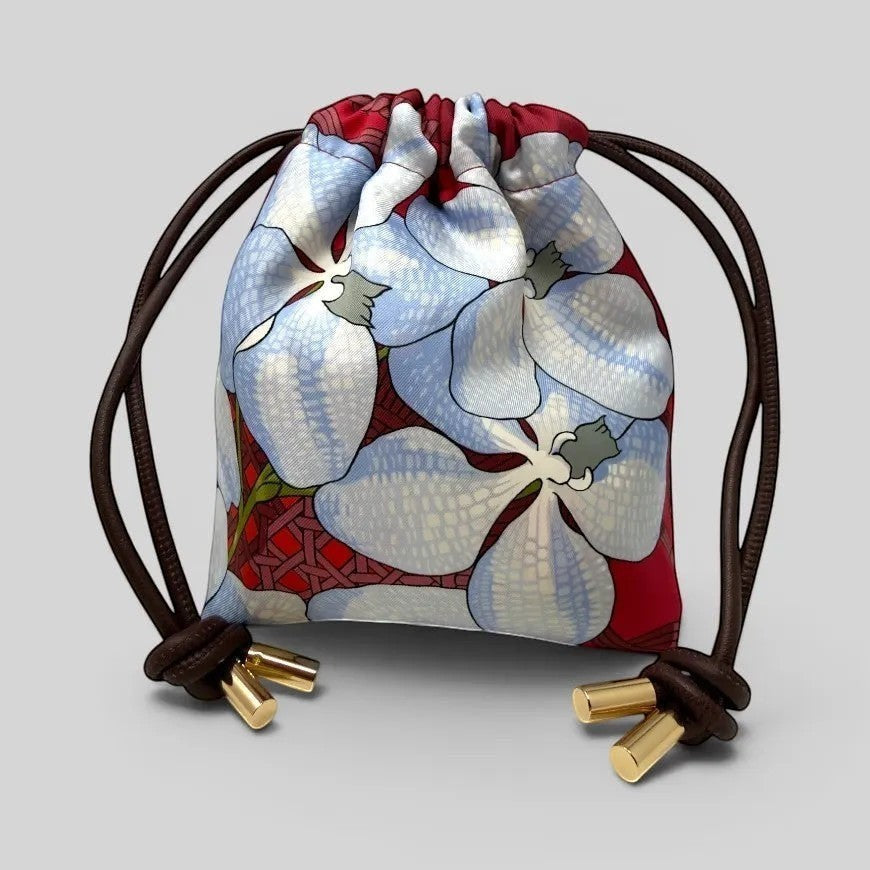 Prettysac Souvenirs D'Asie drawstring pouch with large blue and white floral print on red background, gold hardware.
