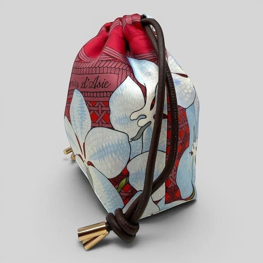 Prettysac Souvenirs D'Asie drawstring pouch with floral print in blue, white, crimson, and geometric patterns. Features leather cords and gold hardware.