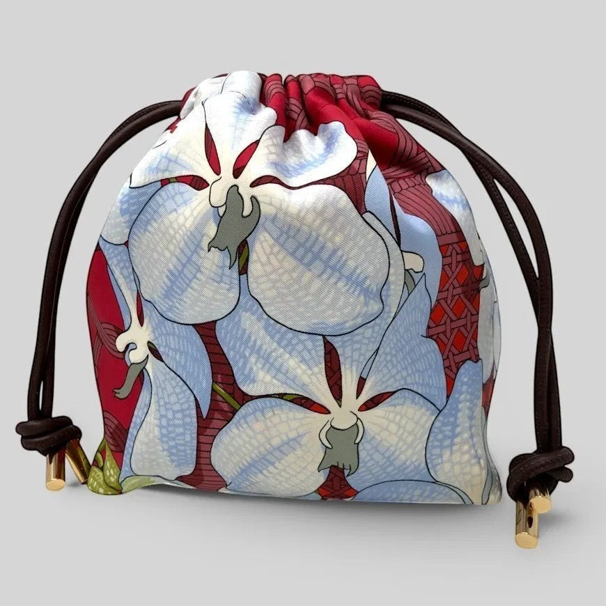 Prettysac Souvenirs D'Asie drawstring pouch with large blue and white floral print on red background. Features dark brown cords and gold hardware.