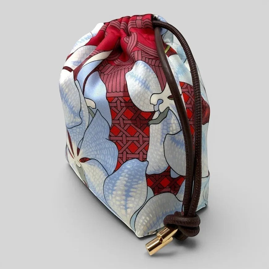Prettysac Souvenirs D'Asie floral print drawstring pouch in blue, white, and crimson with geometric patterns and gold hardware.