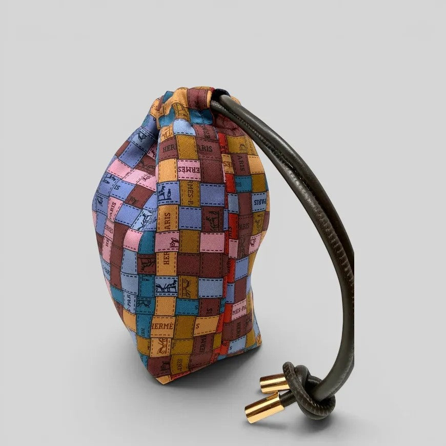 Prettysac artisanal patchwork pouch with leather drawstring and gold-tone hardware. Features iconic motifs and rich colours.