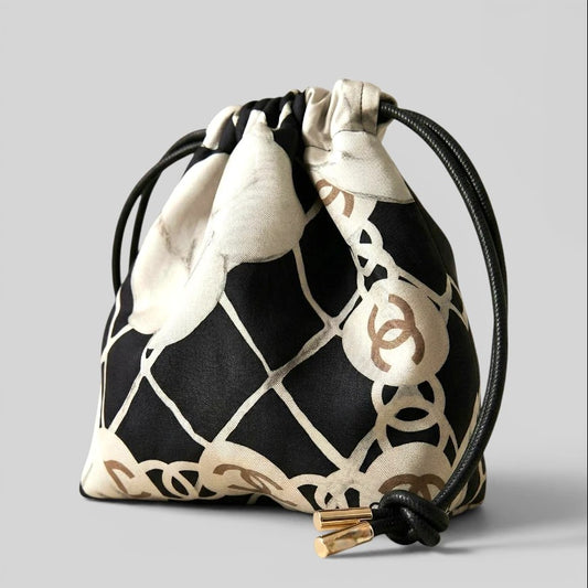 Prettysac black, white, and gold patterned drawstring pouch with black cord and gold accents. Ideal for jewelry or makeup.